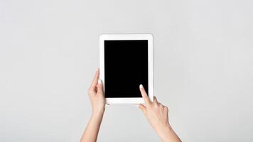 Female hand touching blank screen of tablet computer on white background, mockup for your design. Panorama photo