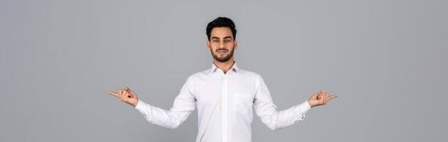 A young Arab businessman stands confidently in a studio, with arms outstretched and a warm smile. He embodies a professional millennial lifestyle focused on entrepreneurship, panorama photo