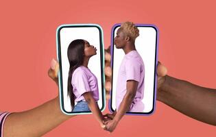 Two people holding smartphones face-to-face while expressing love and connection. Their hands are intertwined, emphasizing the bond despite the digital medium. photo