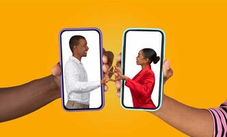 Two people are holding smartphones facing each other, showcasing their hands in a heart shape. They are engaged in a loving conversation through a chat application, symbolizing connection. photo