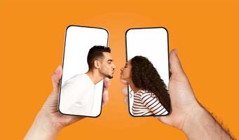 A couple playfully engages in a chat using their smartphones, sharing love and affection. Their hands hold the devices as they lean in for a kiss, embodying connection and romance. photo