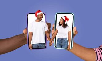 Two people, each holding a smartphone displaying the other, share a moment of love during a festive time. They are smiling and enjoying a conversation, connected despite distance. photo