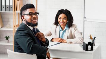 Joyful African American guy having job interview with hiring manager at company office photo