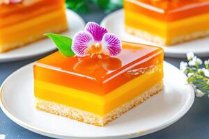 Elegant dessert presentation featuring colorful layered jelly cake adorned with a delicate flower and fresh leaves in a serene setting photo