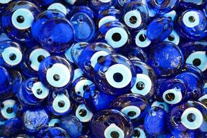 a bunch of blue evil eye keychains hanging on a shelf photo