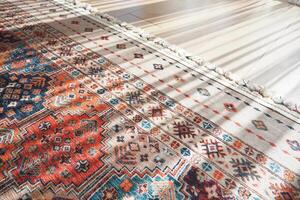 A patterned rug rests on the flooring beside a mirror photo