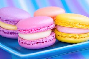 Colorful macarons in vibrant hues styled on a blue plate showcasing dynamic lighting and delightful dessert presentation photo