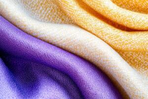 Close-up view of dark blue velvet fabric with folds and reflections paired with a white and lavender scarf showcasing texture and color harmony photo