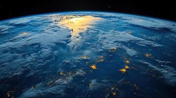 The view highlights illuminated regions on Earth surrounded by clouds and deep blue ocean waters at dusk photo