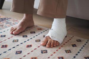 An injured foot wrapped in a bandage is gently resting on the floor, awaiting care and healing photo