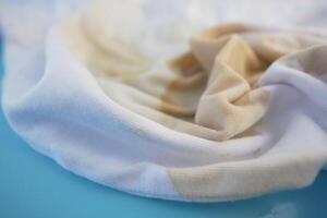 An Elegant Swirl of Soft White Fabric Enhanced by Subtle and Intriguing Color Stains photo
