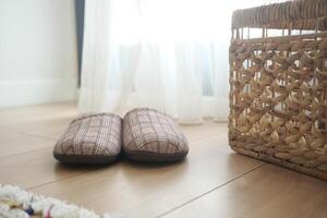 Enjoying Cozy Indoor Slippers Placed by the Window Next to a Woven Basket photo