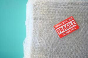A cardboard box marked with a caution label for fragile goods handling during shipping photo
