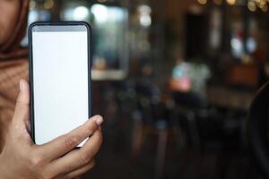 A Person Holding a Smartphone While Sitting in a Cafe Setting Enjoying Time photo