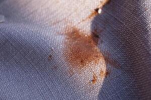 Stained Fabric CloseUp Detailed View of Patterned Material Featuring an Orange Mark photo