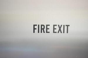 Fire Exit Signage prominently displayed in an Urban Environment alongside a Yellow Taxi cab photo