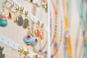 A Colorful Jewelry Display Featuring Unique and Artistic Earrings and Necklaces photo