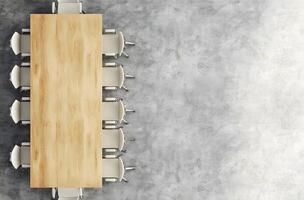 Top View of a Wooden Table with White Chairs in a Concrete Room photo