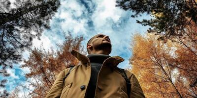 Man looking up in autumn woods photo
