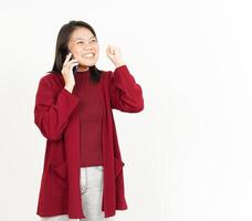 Talking on the Phone with with Happy Face Of Beautiful Asian Woman Wearing Red Shirt photo