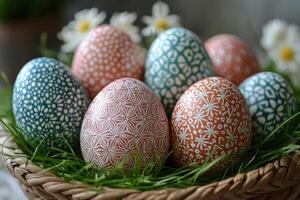 Decorated easter eggs lying in grass nest with daisies in background photo