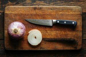 Sliced red onion and knife resting on rustic cutting board photo