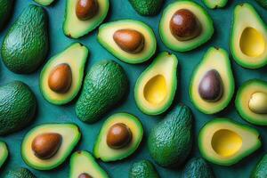 Fresh avocados pattern showing both halves and whole fruits on green background photo