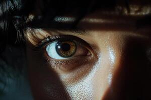 Close-up of a person's eye capturing light and shadow in a dramatic setting during the evening photo