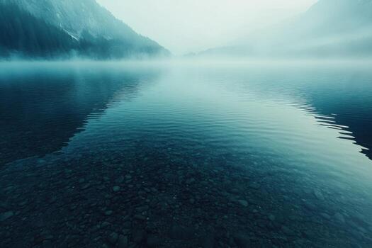 Tranquil morning mist over calm lake reflecting majestic mountains in serene setting photo