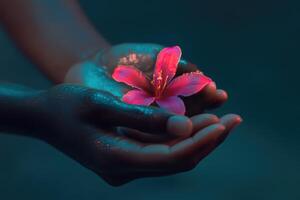 Hands gently holding a vibrant pink flower with water droplets in a serene atmosphere photo