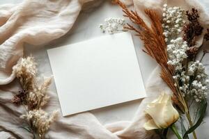 Elegant composition of dried flowers and a blank card arranged on a soft fabric background for personalized messages photo