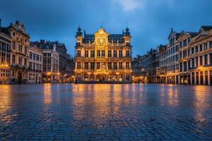 Historic square in Brussels illuminated at twilight with reflections on cobblestone streets photo
