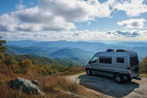 Scenic mountain view with a camper van parked at a lookout during autumn photo