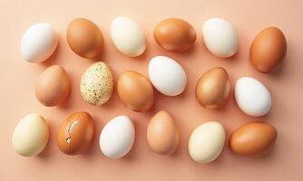 Assorted eggs Various colors and textures Peach background photo