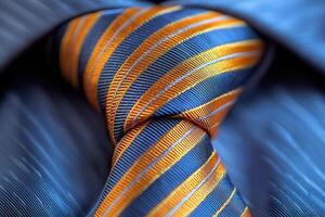 A close up view of a neatly knotted tie featuring vibrant orange and blue stripes, set against a formal shirt. The fabric texture and colors create a sophisticated appearance. photo