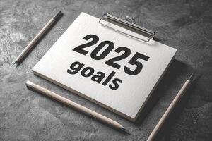 A notepad displaying the text 2025 goals is placed on a textured surface, surrounded by pencils. This setup emphasizes organization and planning for future achievements. photo