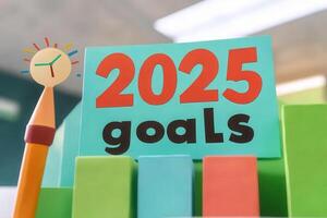 A vibrant display of a sign that reads 2025 goals surrounded by colorful blocks and a pencil with a clock. This setup emphasizes the importance of planning and organization for future achievements. photo