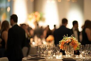 Guests are mingling at an upscale event, surrounded by tables adorned with elegant floral centerpieces. The warm lighting creates a sophisticated atmosphere perfect for socializing and celebration. photo