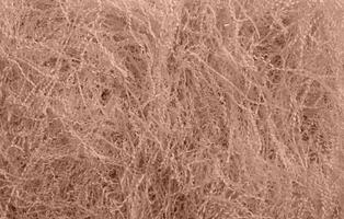 Shredded paper texture, filling for gift box, stuffing and shipping. Brown decorative straws fillers for product placement. Paper trash texture. Selective focus. Mocha Mousse, Color of the Year 2025. photo