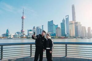 Couple traveler visiting in Shanghai, China. Tourists sightseeing Shanghai view of Lujiazui on The Bund of Shanghai. landmark and popular for tourism attractions. Vacation concept photo