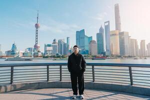 man traveler visiting in Shanghai, China. male Tourist sightseeing Shanghai view of Lujiazui in The Bund of Shanghai. landmark and popular for tourism attractions. Vacation concept photo