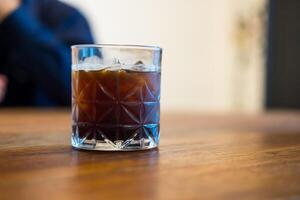 Ice cold brew coffee in glass on wood table. photo