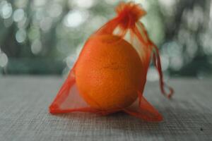 Oranges in a red mesh bag. Concept of traditional Chinese new year lucky fruit photo