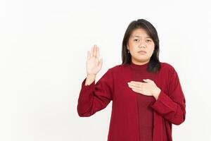 Swearing or Promise Gesture Of Beautiful Asian Woman Wearing Red Shirt Isolated On White Background photo