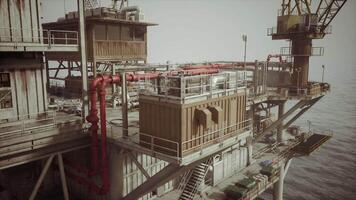 Detailed view of an old oil platform with operational structures in the ocean video