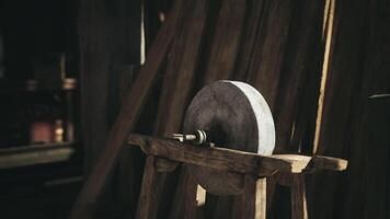 A vintage sharpening stone on a wooden stand in a rustic workshop video