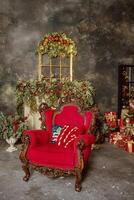 A red chair in front of a fireplace with christmas decorations photo