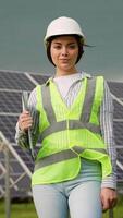 Portrait of professional woman engineer in uniform with screwdriver in solar power station. Alternative energy to conserve the world's energy concept. Vertical video