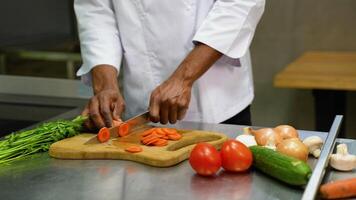 Close up of african american hands using professional knife to chop finely vegetables for stew recipe video