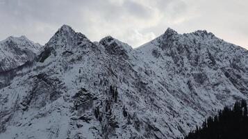 Snow Covered Mountain Peaks and Clouds in Kalam, North Pakistan photo